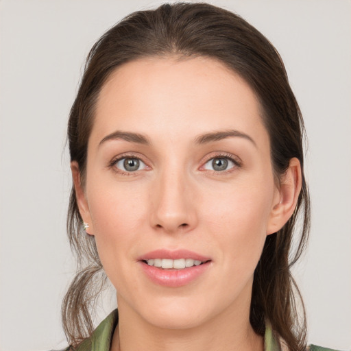 Joyful white young-adult female with long  brown hair and grey eyes