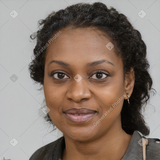 Joyful black young-adult female with long  black hair and brown eyes