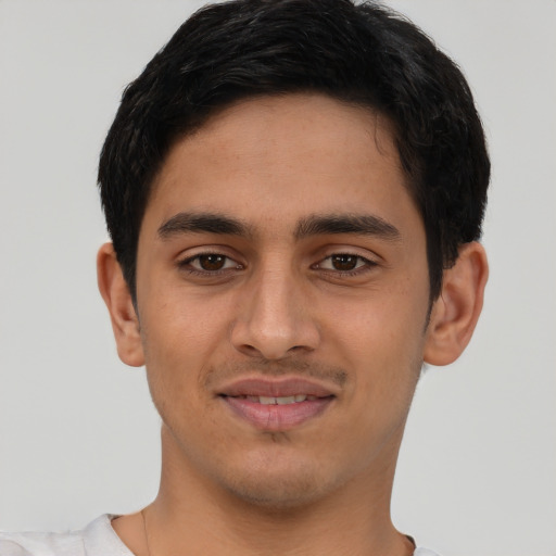 Joyful latino young-adult male with short  brown hair and brown eyes