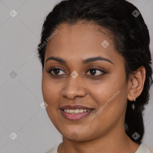 Joyful black young-adult female with long  black hair and brown eyes