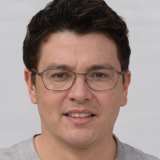 Joyful white adult male with short  brown hair and grey eyes