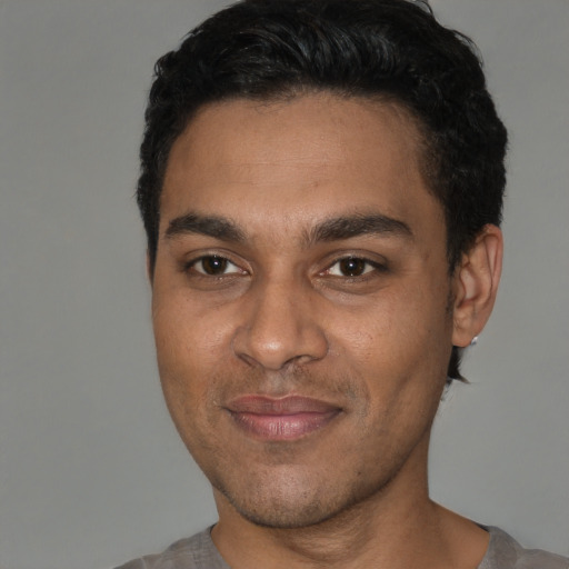 Joyful black young-adult male with short  brown hair and brown eyes