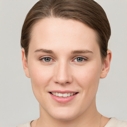 Joyful white young-adult female with short  brown hair and grey eyes