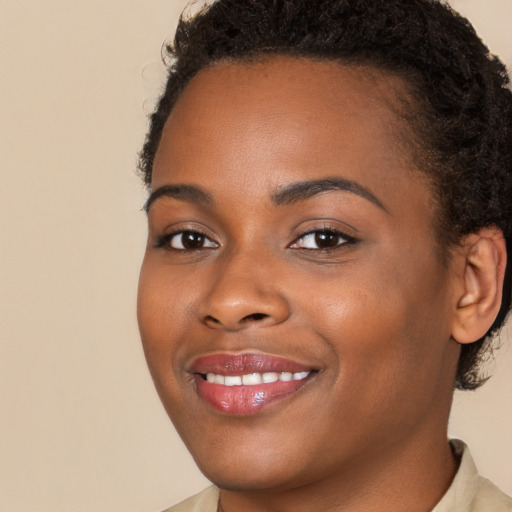 Joyful black young-adult female with short  brown hair and brown eyes