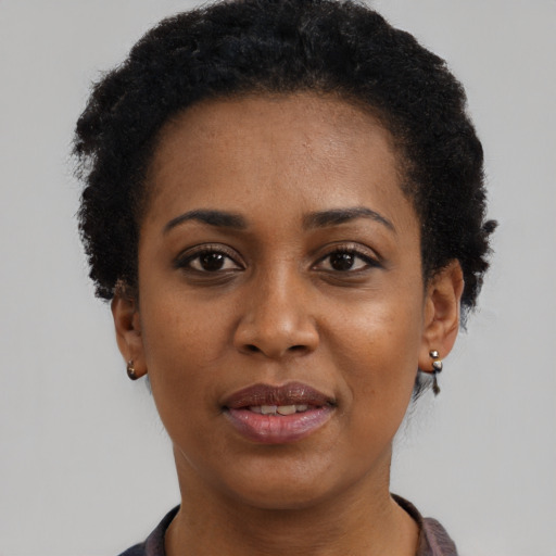 Joyful black young-adult female with short  black hair and brown eyes