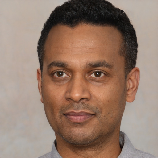 Joyful latino adult male with short  black hair and brown eyes