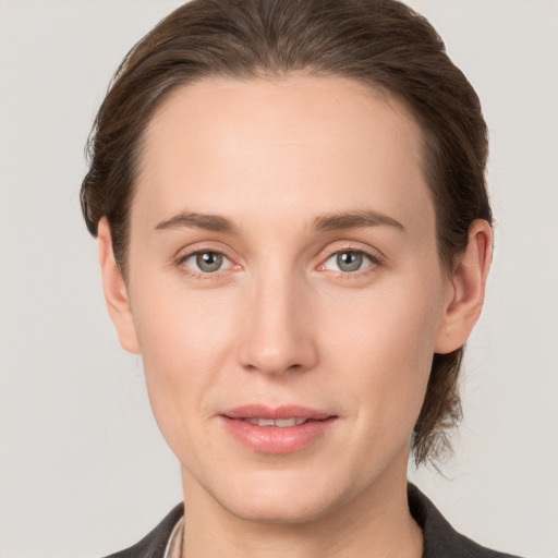 Joyful white young-adult female with medium  brown hair and grey eyes