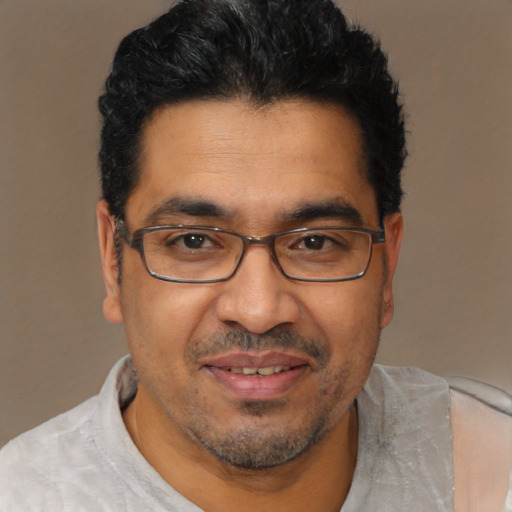 Joyful latino adult male with short  brown hair and brown eyes