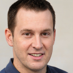 Joyful white adult male with short  brown hair and brown eyes