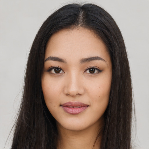 Joyful latino young-adult female with long  brown hair and brown eyes