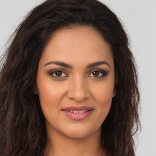 Joyful latino young-adult female with long  brown hair and brown eyes