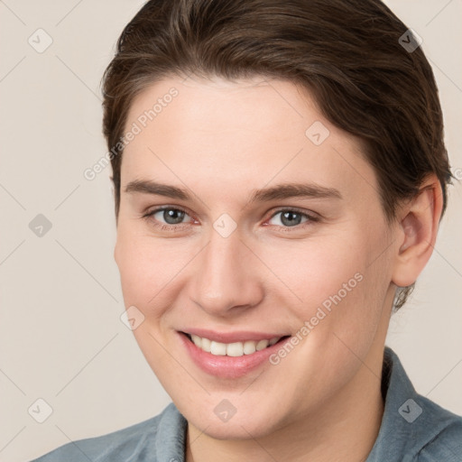 Joyful white young-adult female with short  brown hair and grey eyes