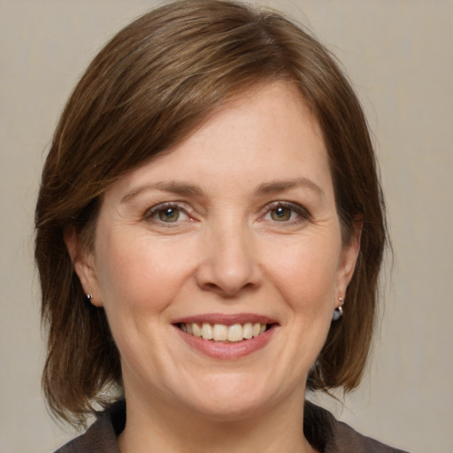 Joyful white adult female with medium  brown hair and brown eyes