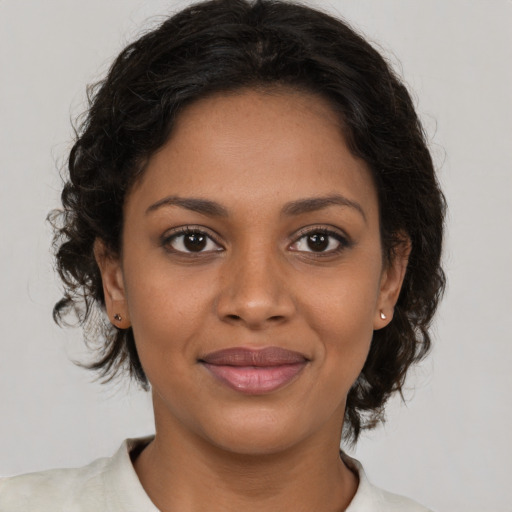 Joyful black young-adult female with medium  brown hair and brown eyes