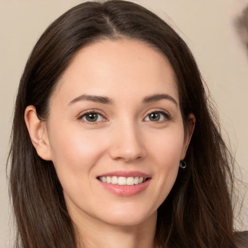 Joyful white young-adult female with long  brown hair and brown eyes