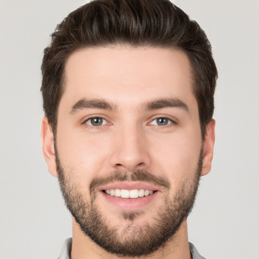 Joyful white young-adult male with short  brown hair and brown eyes