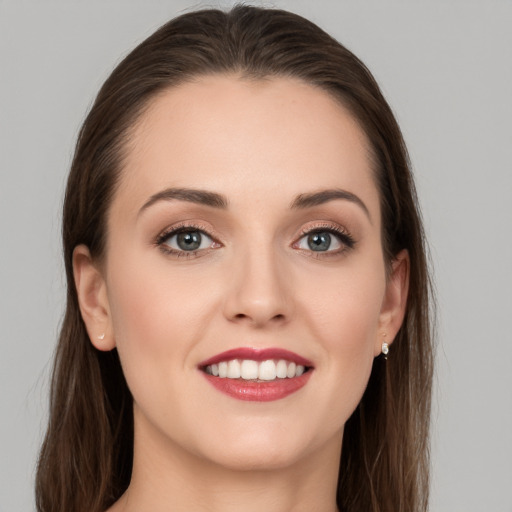 Joyful white young-adult female with long  brown hair and grey eyes