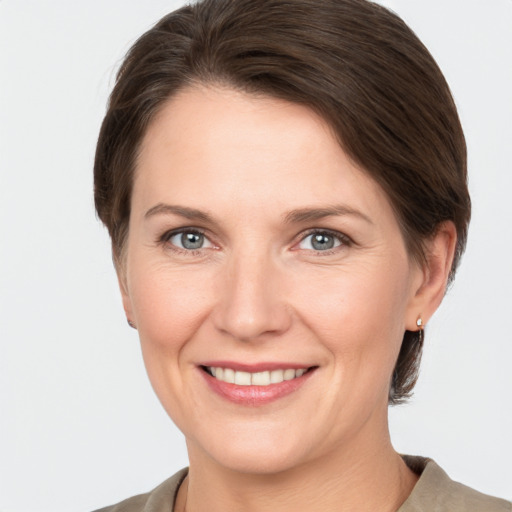 Joyful white adult female with medium  brown hair and grey eyes