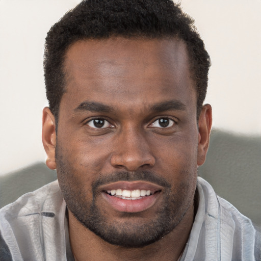 Joyful black young-adult male with short  brown hair and brown eyes