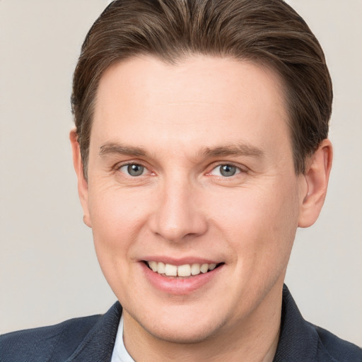 Joyful white young-adult male with short  brown hair and grey eyes