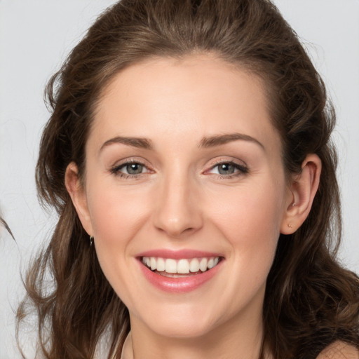 Joyful white young-adult female with long  brown hair and grey eyes