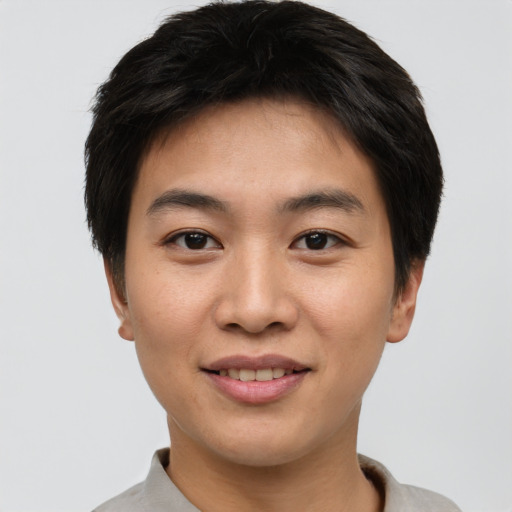 Joyful asian young-adult male with short  brown hair and brown eyes