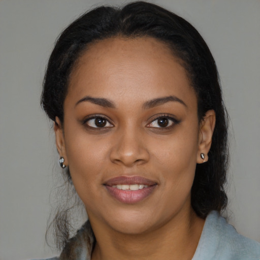 Joyful black young-adult female with long  brown hair and brown eyes