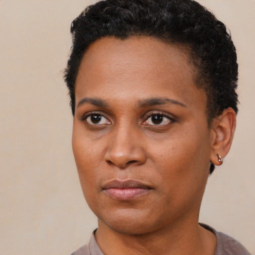 Joyful black young-adult female with short  black hair and brown eyes