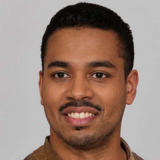 Joyful latino young-adult male with short  black hair and brown eyes