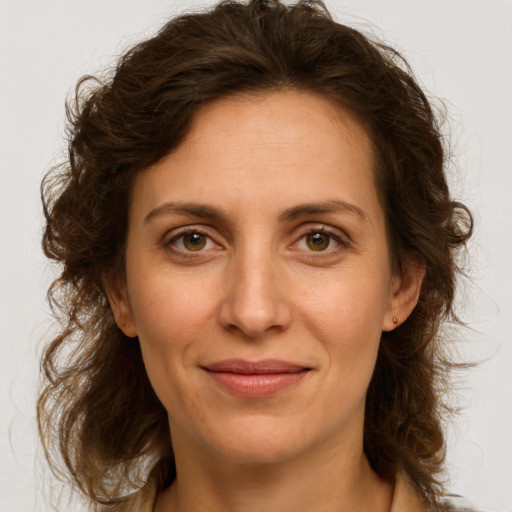 Joyful white adult female with long  brown hair and green eyes