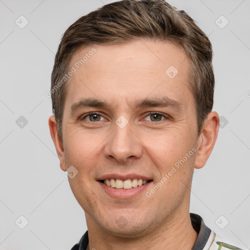 Joyful white young-adult male with short  brown hair and grey eyes