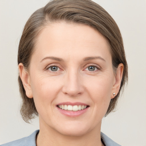 Joyful white adult female with medium  brown hair and grey eyes