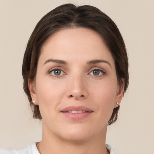 Joyful white young-adult female with medium  brown hair and grey eyes