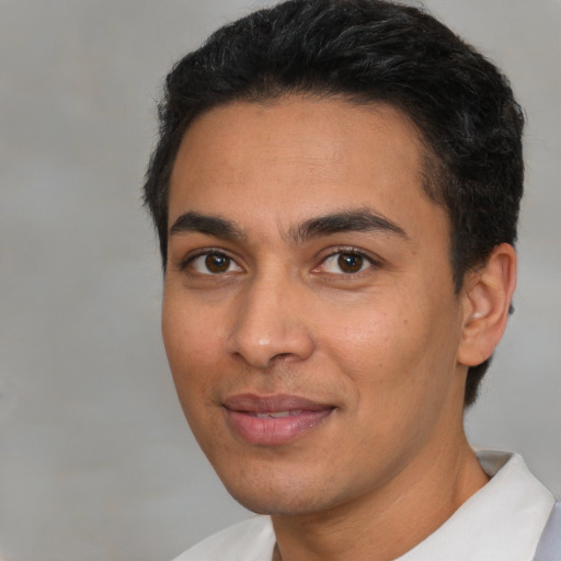 Joyful latino young-adult male with short  black hair and brown eyes