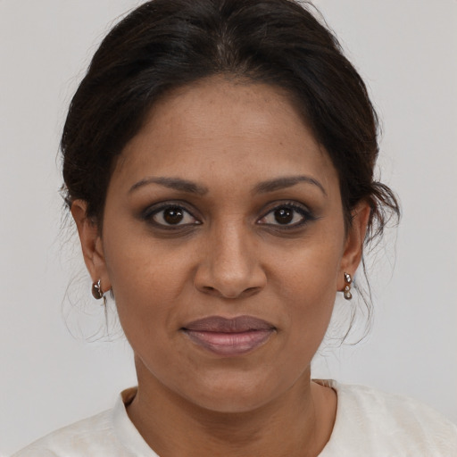 Joyful black adult female with medium  brown hair and brown eyes
