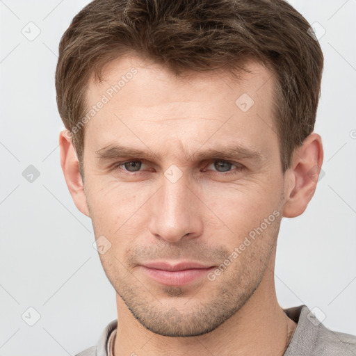 Joyful white young-adult male with short  brown hair and grey eyes