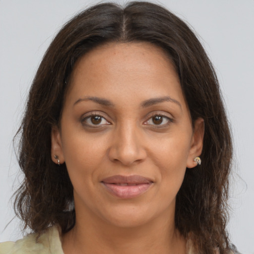 Joyful black young-adult female with long  brown hair and brown eyes