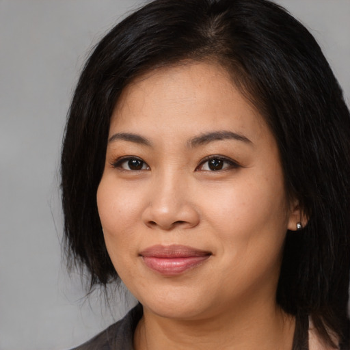 Joyful asian young-adult female with long  black hair and brown eyes