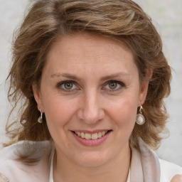 Joyful white adult female with medium  brown hair and blue eyes