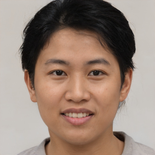 Joyful asian young-adult female with short  black hair and brown eyes