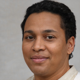 Joyful latino young-adult male with short  brown hair and brown eyes