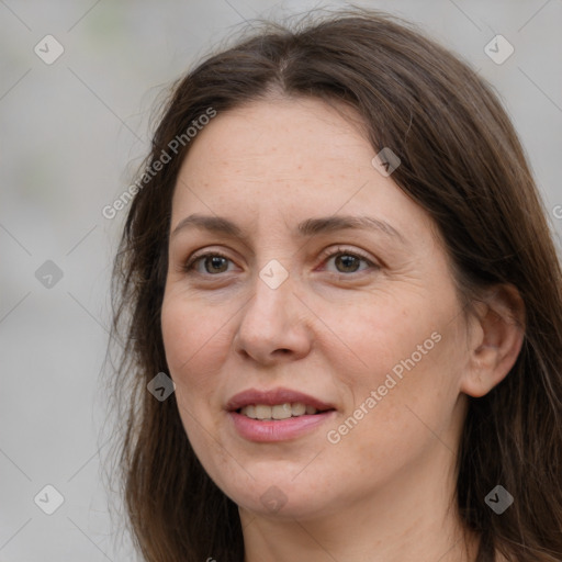 Joyful white adult female with long  brown hair and grey eyes