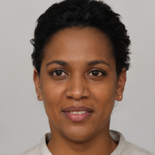 Joyful black young-adult female with short  black hair and brown eyes