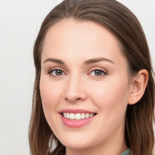 Joyful white young-adult female with long  brown hair and grey eyes