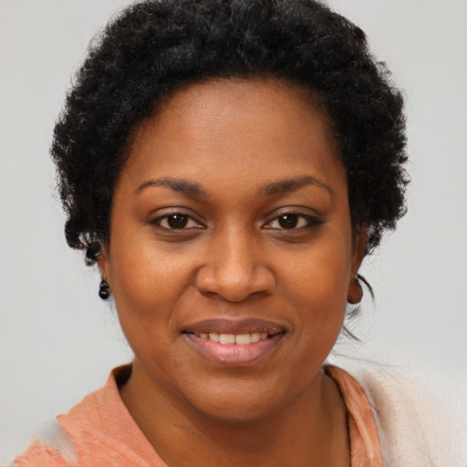 Joyful black young-adult female with short  brown hair and brown eyes