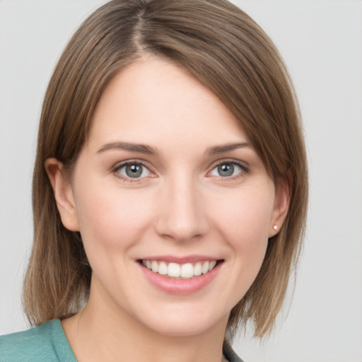 Joyful white young-adult female with medium  brown hair and grey eyes