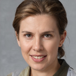 Joyful white adult female with medium  brown hair and grey eyes