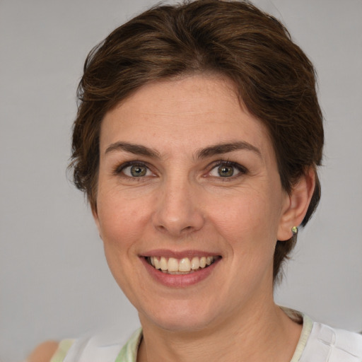 Joyful white adult female with medium  brown hair and green eyes