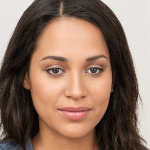 Joyful latino young-adult female with long  brown hair and brown eyes