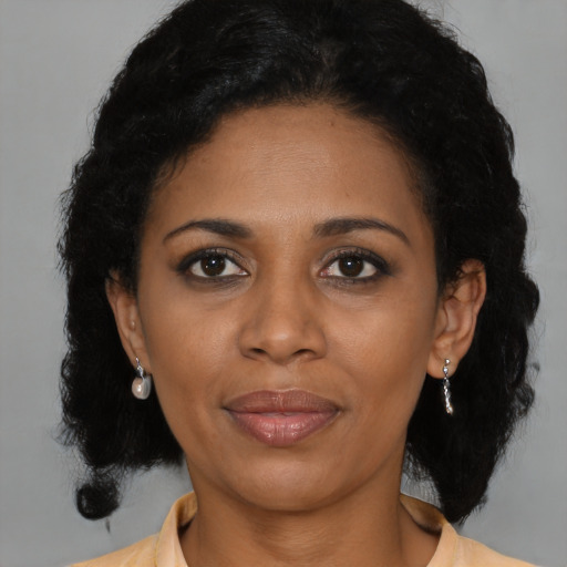 Joyful latino adult female with medium  black hair and brown eyes
